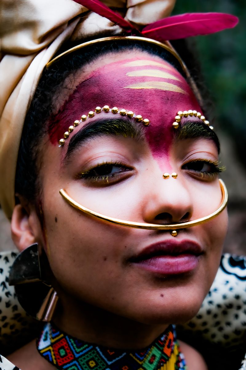 Close-up of face paint, gold jewellery and beadwork