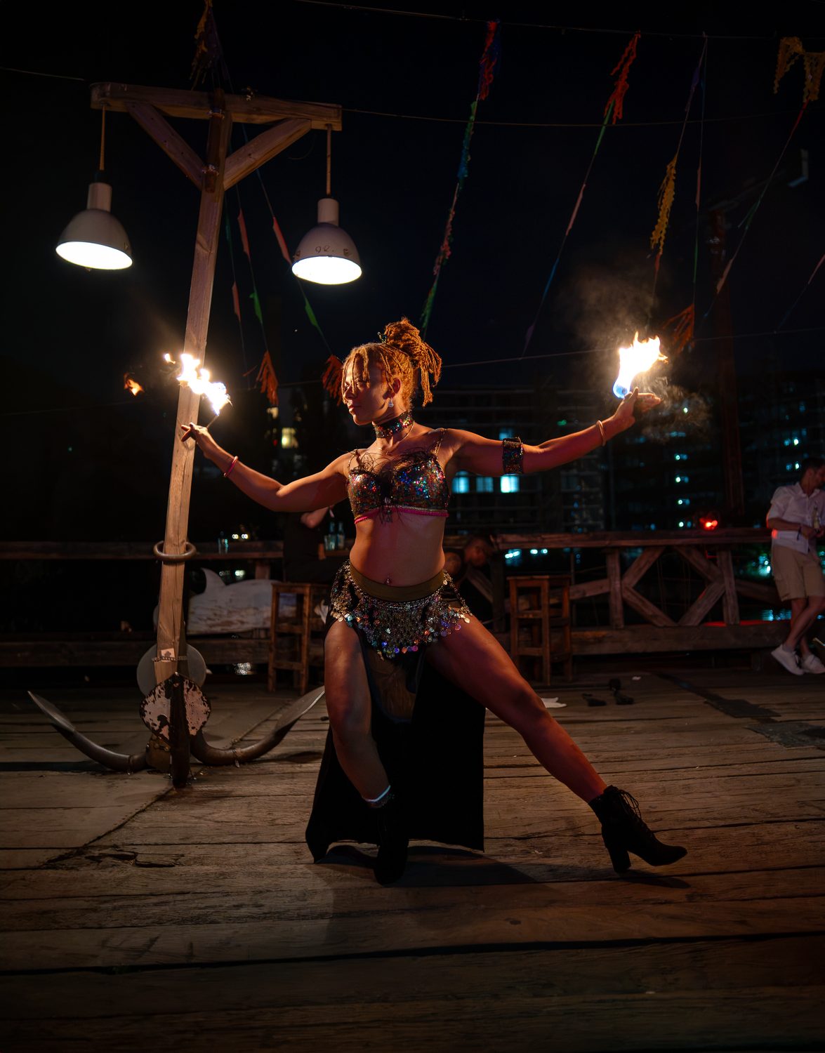 Fire-fan performance on stage, flames fanned out at night
