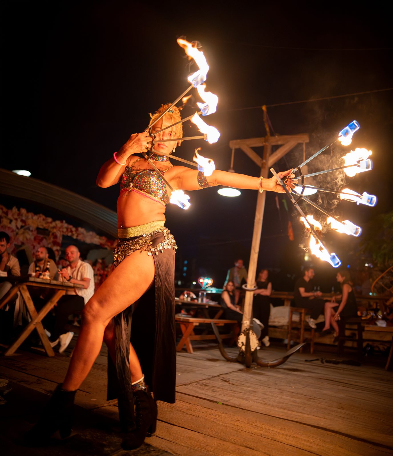 Shida performing a fire-fan routine on stage before a live audience