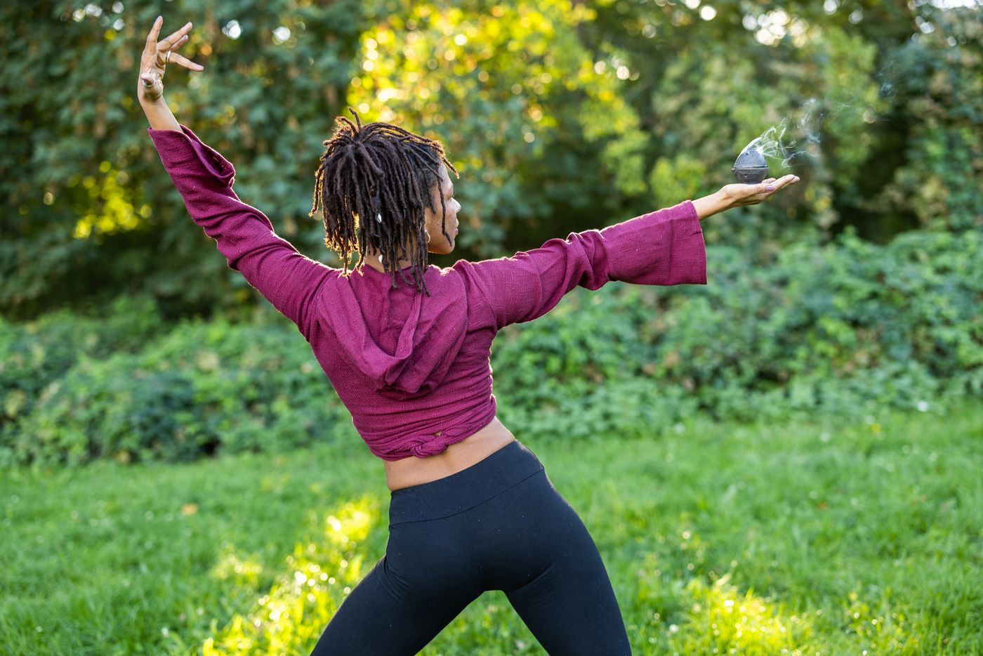 Movement and ritual, arms outstretched in a park